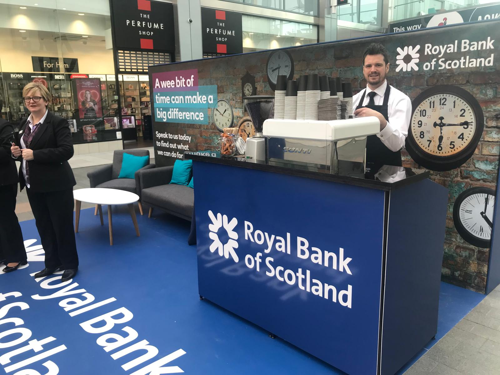 Barista serving at a Royal Bank of Scotland mobile coffee bar in a shopping centre