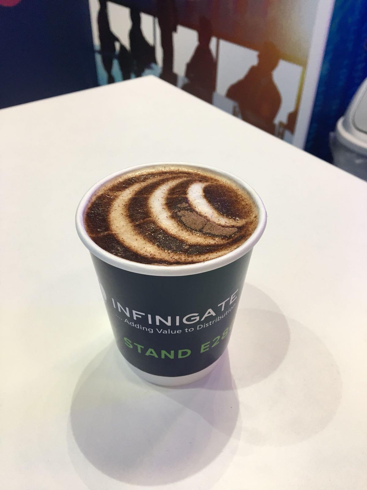 Infinigate branded takeaway coffee with latte art at an exhibition